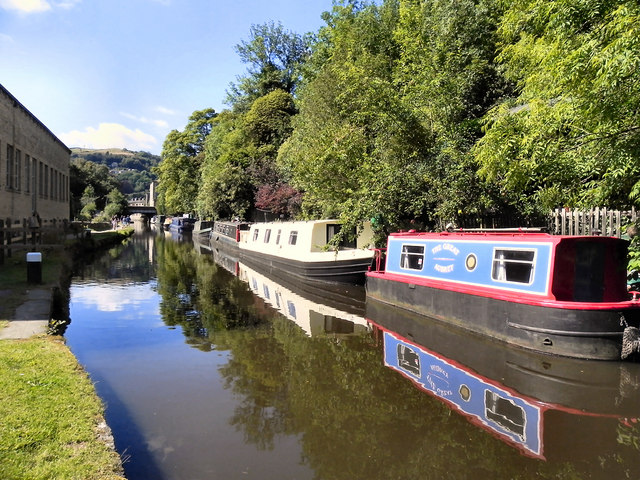 Canal boats can be seen moored along the edge of Rochdale Canal, Hebden Bridge